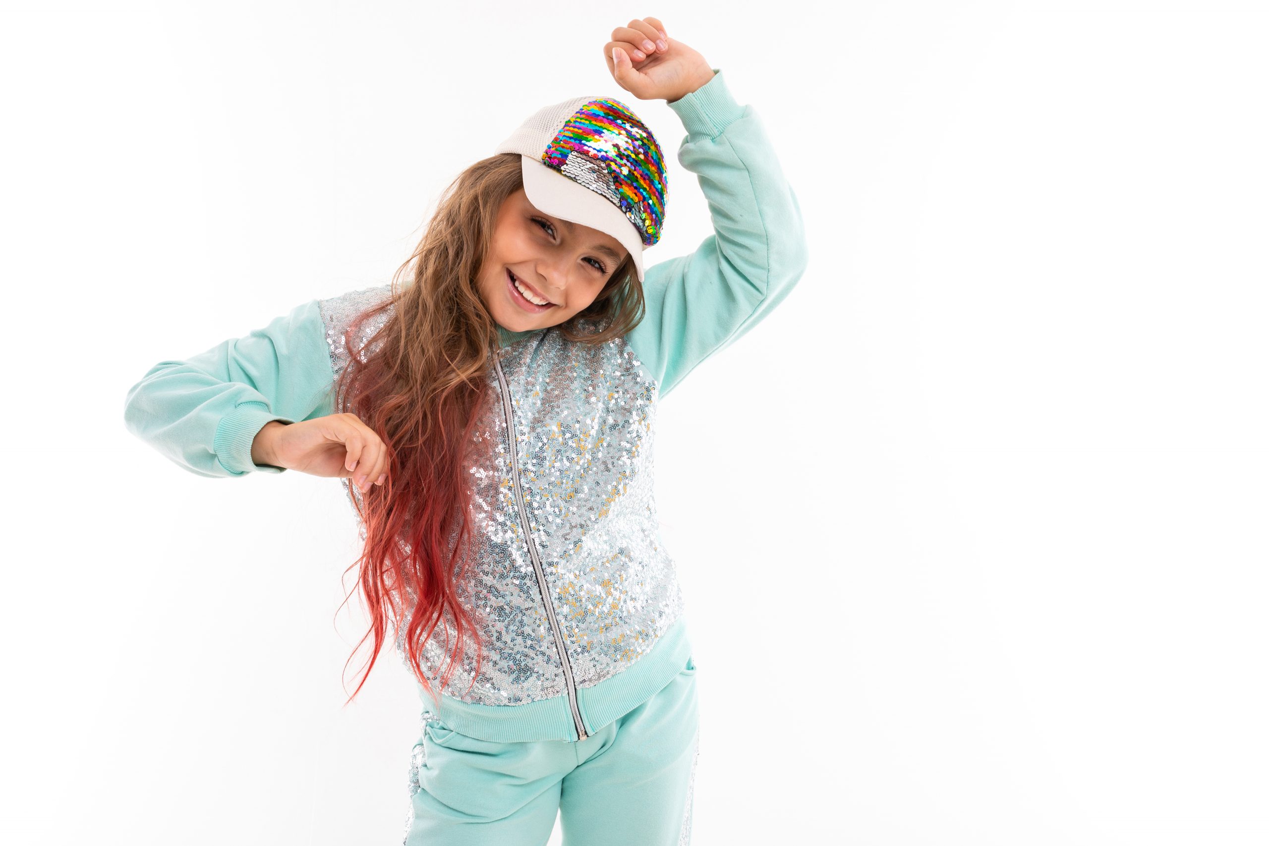 Little pretty caucasian girl in a tracksuit dancing, picture isolated on white background